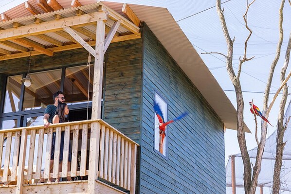 Un edificio de madera con un balcón y un ventanal grande.
