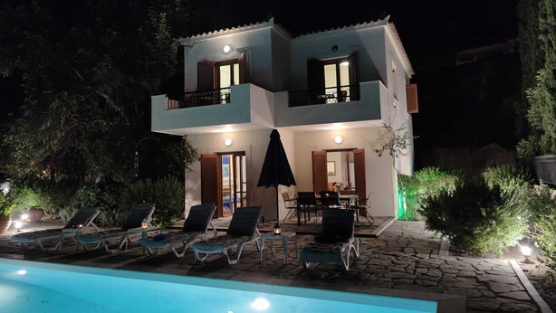 A two-story building with a swimming pool, lounge chairs, and a table with chairs outside. - Relax with the whole family at this peaceful place to stay. (tzemi)