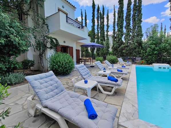 A poolside area with lounge chairs and a swimming pool.