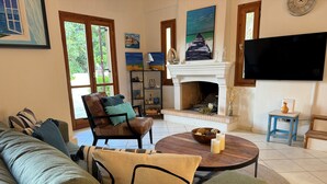A living room with a sofa, armchairs, a coffee table, a fireplace, and a TV. - Relax with the whole family at this peaceful place to stay. (tzemi)