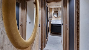 A hallway with wooden walls, a large mirror, and a sink area. - Spacious apartment near slopes with jacuzzi and parking (Montvalezan-La Rosière)