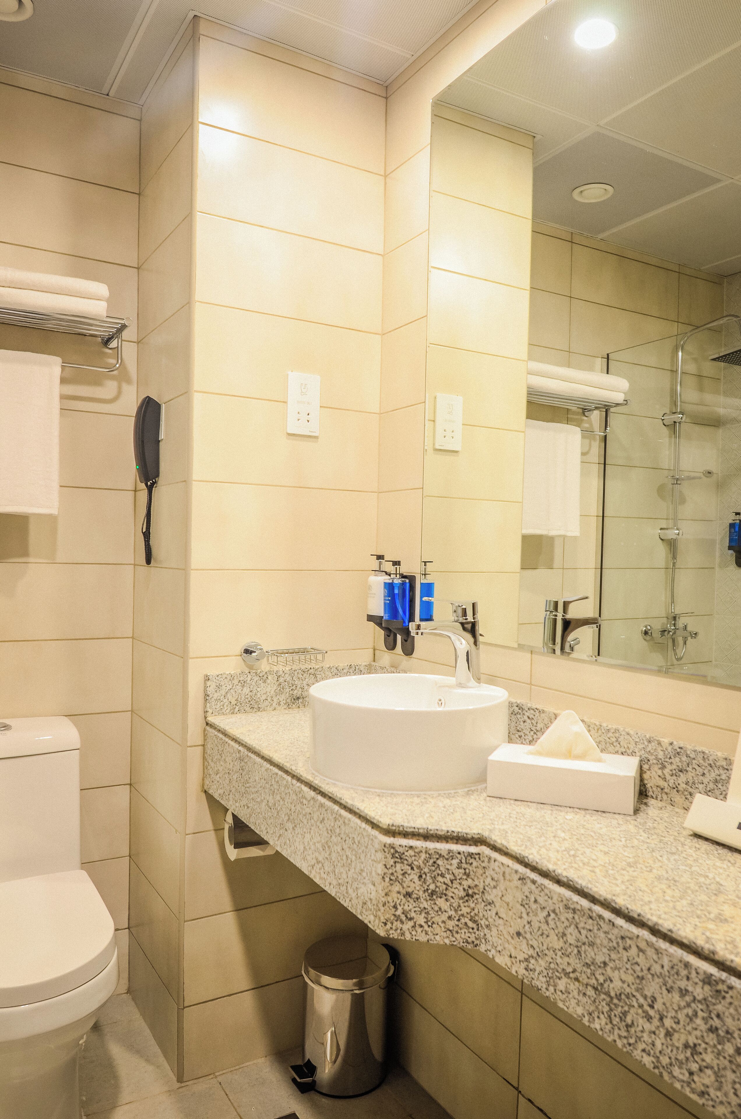Ein Badezimmer mit Toilette, Waschbecken mit Spiegel und Duschbereich.