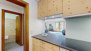 Una cocina moderna con armarios de madera, encimera negra y estufa empotrada.