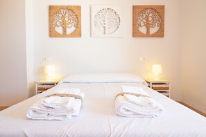Et hotelværelse med en seng, to sengeborde og tre billeder på væggen.