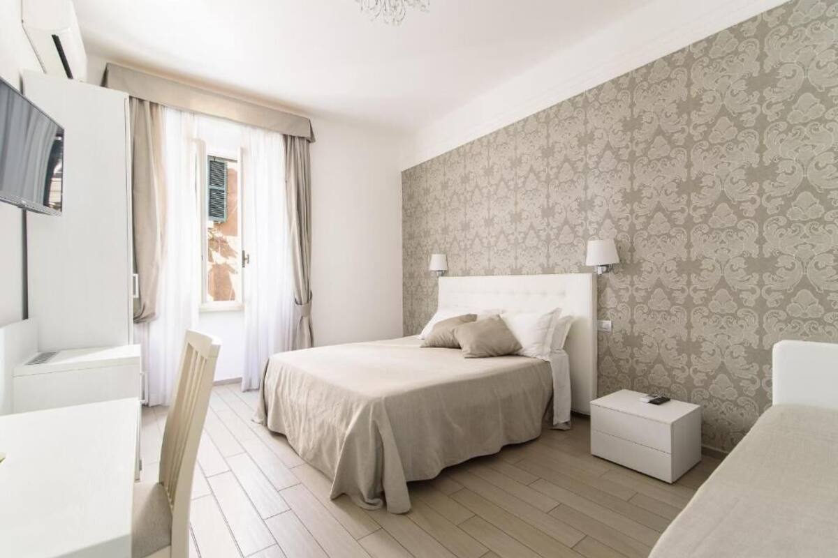 A bedroom with a bed, bedside tables, a desk, and a chair.