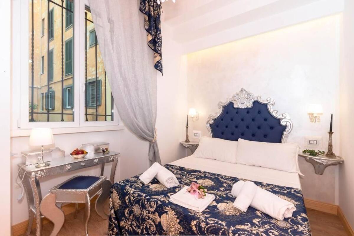 A hotel room with a large bed, a desk, and a window.