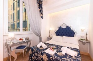 A hotel room with a large bed, a desk, and a window. - Roma Charming Rooms (Rome)