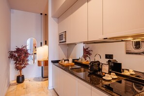 A modern kitchen with a built-in microwave, a coffee machine, and a sink. - Retreat Studio in Bolhão Market (Oporto)