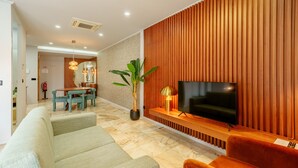 A modern living room with a TV, sofa, and a dining area.