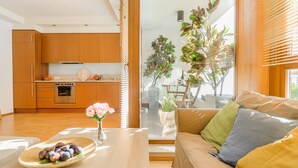 Une cuisine moderne avec des meubles en bois, un coin repas avec une table et un canapé agrémenté de coussins.