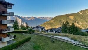 Un edificio moderno con un balcón que da a un paisaje montañoso.