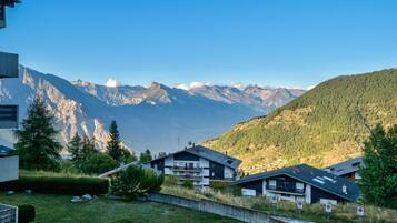 Un quartier résidentiel avec des maisons, un ciel dégagé et des montagnes en arrière-plan.
