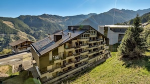 A multi-story building with balconies, situated in a mountainous area with clear skies. - Appartement Savoleyres 30 - La Tzoumaz, 4 Vallees (La Tzoumaz)