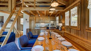 A wooden interior with a dining table set for a meal, blue upholstered chairs, and a staircase. - Chalet Bellevue - Jacuzzi - Views - La Tzoumaz, 4 Vallees (La Tzoumaz)