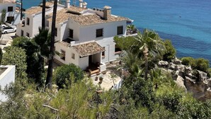 A coastal building with a terrace, surrounded by palm trees and a view of the sea. - Genuine Spanish villa - large private pool - close to the beach - sun all day (Benissa)