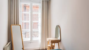 A room with a large mirror, a wooden dresser, and a bed with a blue headboard. - 2 Bed Apartment Right on Trafalgar Square  (London)