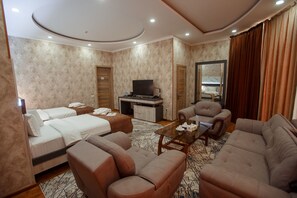 Una habitación de hotel con dos camas, un sofá, una silla, un televisor y un espejo.