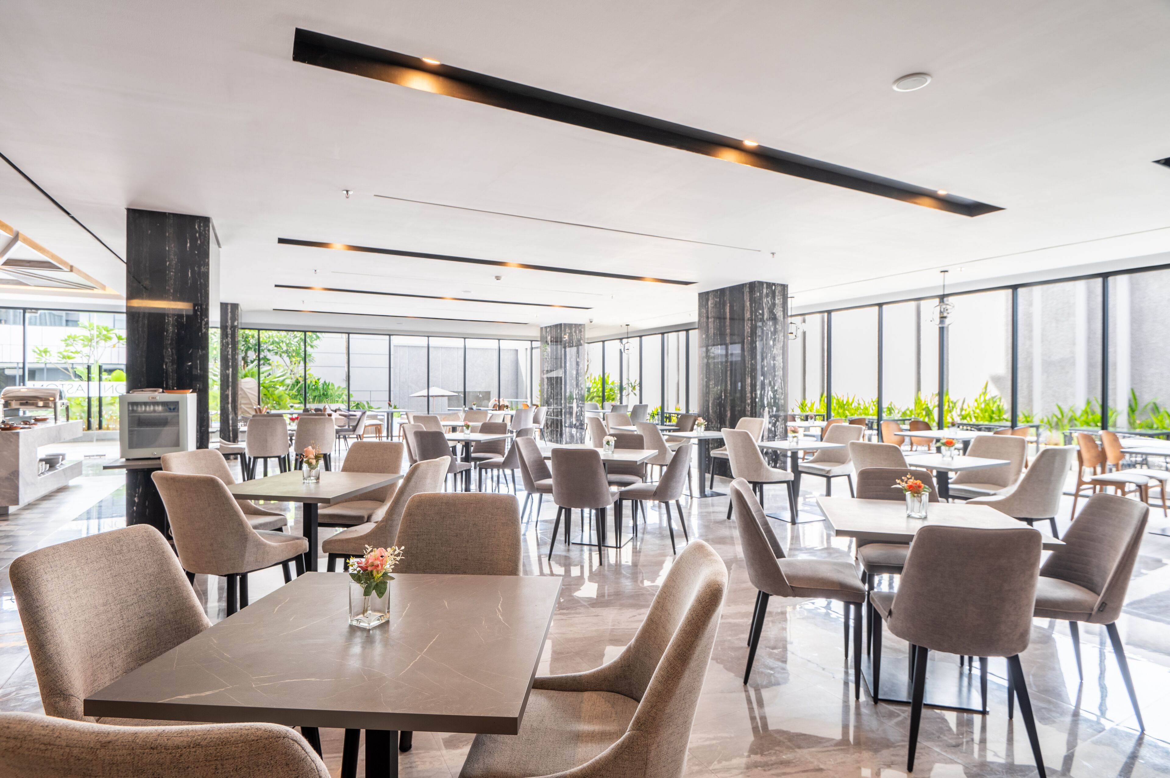 A modern restaurant with a spacious layout, large windows, and a clean, contemporary design.