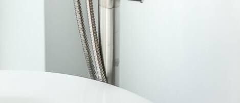 A modern bathroom with a sleek, metallic shower faucet and a flexible hose.
