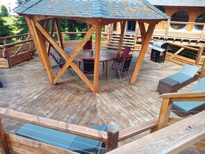Enjoy dining and socializing on the deck with a round table and comfortable seating, plus a barbecue grill for outdoor cooking.