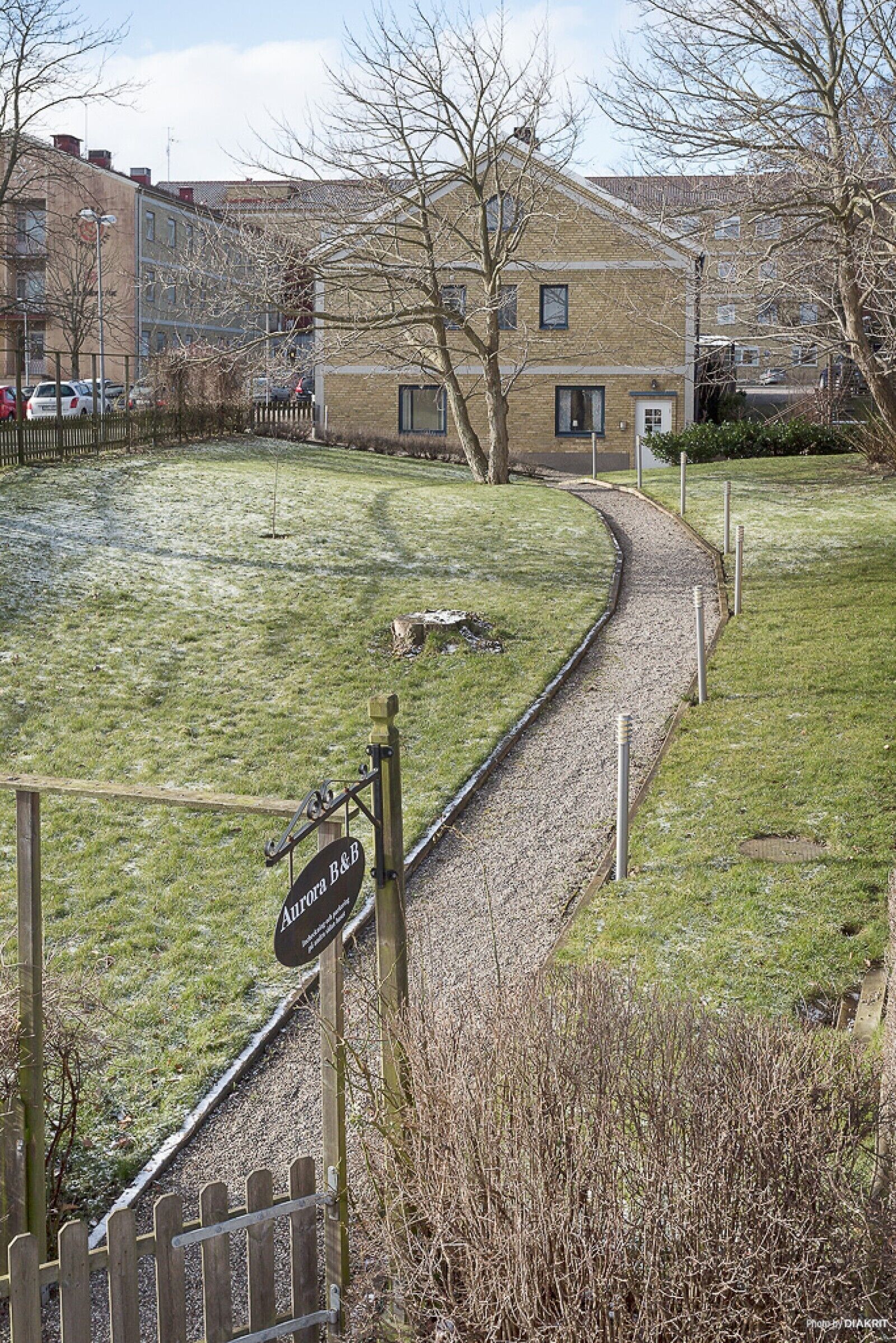A pathway leading to a building with a sign reading "Aurora B&B".