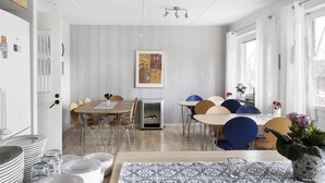 A modern dining area with a wooden table, blue and brown chairs, and a fireplace.