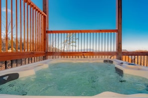 Relax in the hot tub on the elevated deck with a scenic view.
