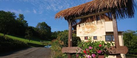 A rustic building with a thatched roof and a sign reading "Gasthaus Paulo".