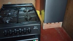 A kitchen with a gas stove and a refrigerator. - Cosy homes ltd (Mlolongo)
