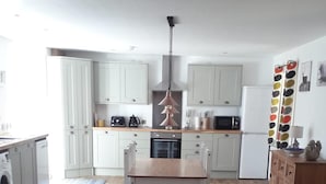 A living room with a sofa, a coffee table, and a kitchen in the background. - Lovely House Near Loch Ness in Scotland, UK (Inverness)