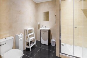 Un bagno moderno con WC, lavandino e doccia.