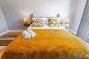 Una camera d'albergo con un letto, due comodini e una finestra con tende.