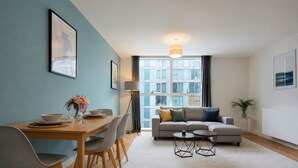 A modern living room with a dining table, sofa, and coffee table.