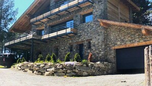 A two-story stone building with a wooden balcony and a garage. - Vaste et Prestigieux Chalet à Font Romeu Pyrénées 2000 (Bolquère)