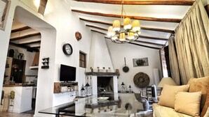 A spacious living area with a glass coffee table, a fireplace, and a cozy sofa. - THE BALCONY OF THE OLIVE TREES (Luque)