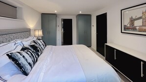 A bedroom with a bed, a nightstand, a lamp, a wardrobe, and a framed picture on the wall. - Impeccable Farm Apartment in Walberton, England (Arundel)