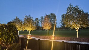 A backyard with a brick wall, a grassy lawn, and trees. - Impeccable Farm Apartment in Walberton, England (Arundel)