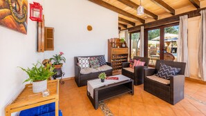 A furnished living area with a sofa, two armchairs, a coffee table, and a bookshelf. - Pet-Friendly "Finca Pep" with Pool & Wi-Fi (Sineu)