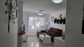 Una sala de estar moderna con un sofá, una mesita de centro y un televisor.