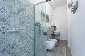 A modern bathroom with a shower, toilet, bidet, and a glass-enclosed shower area. - Torino 3.0 sulla Via del Treno by Wonderful Italy (Torino)