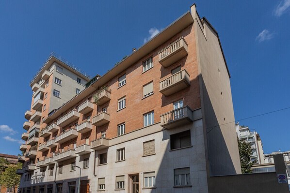 A multi-story residential building with balconies, a flat facade, and a clear blue sky. - Torino 3.0 sulla Via del Treno by Wonderful Italy (Torino)