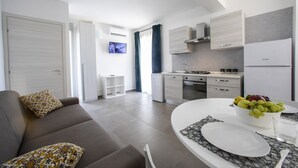 A modern apartment with a living room, kitchen, and dining area.