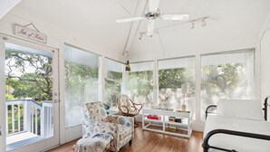 Ein heller, freundlicher Raum mit großem Fenster, Deckenventilator und einem Bett.