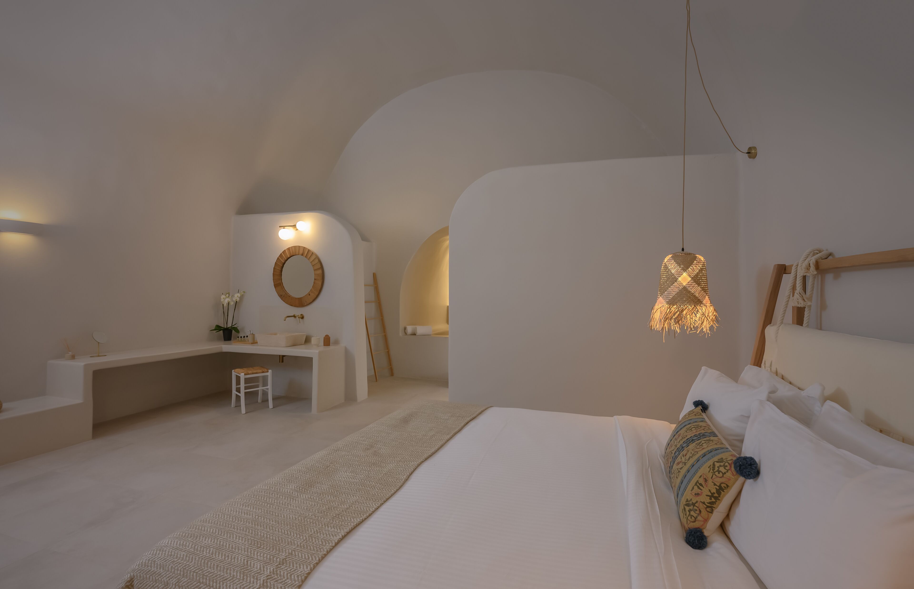 Een minimalistische slaapkamer met een bed, nachtkastje en bureau.
