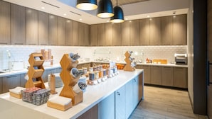 A modern kitchen with wooden cabinets, a white countertop, and pendant lighting. - Residence Inn by Marriott San Francisco Airport Millbrae Station (Millbrae)