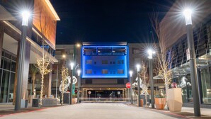 A modern building with a blue-lit entrance, a stop sign, and a clear sky. - Residence Inn by Marriott San Francisco Airport Millbrae Station (Millbrae)