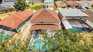 Ett flygbildsbild av ett bostadsområde med hus, en swimmingpool och solpaneler.