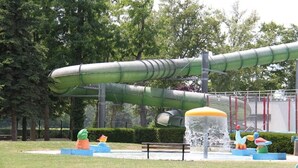 A water play area with slides and a fountain, surrounded by benches and greenery. - Location de Mobil Home Camping Tohapi en Alsace (Biesheim)