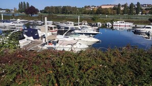 A marina with several boats docked, surrounded by greenery and a clear sky. - Location de Mobil Home Camping Tohapi en Alsace (Biesheim)