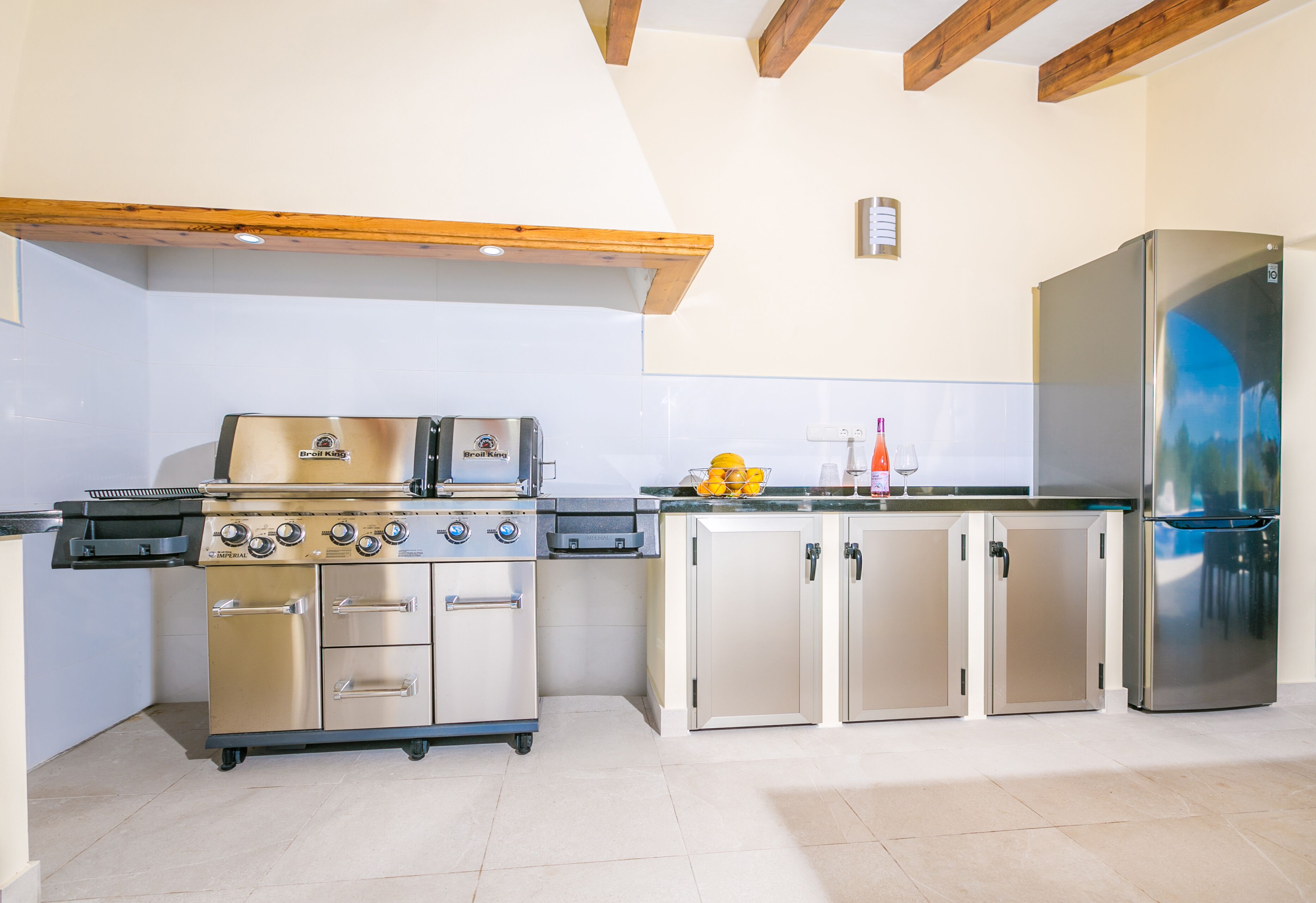 Cocina compacta con una parrilla de acero inoxidable, un refrigerador y armarios.